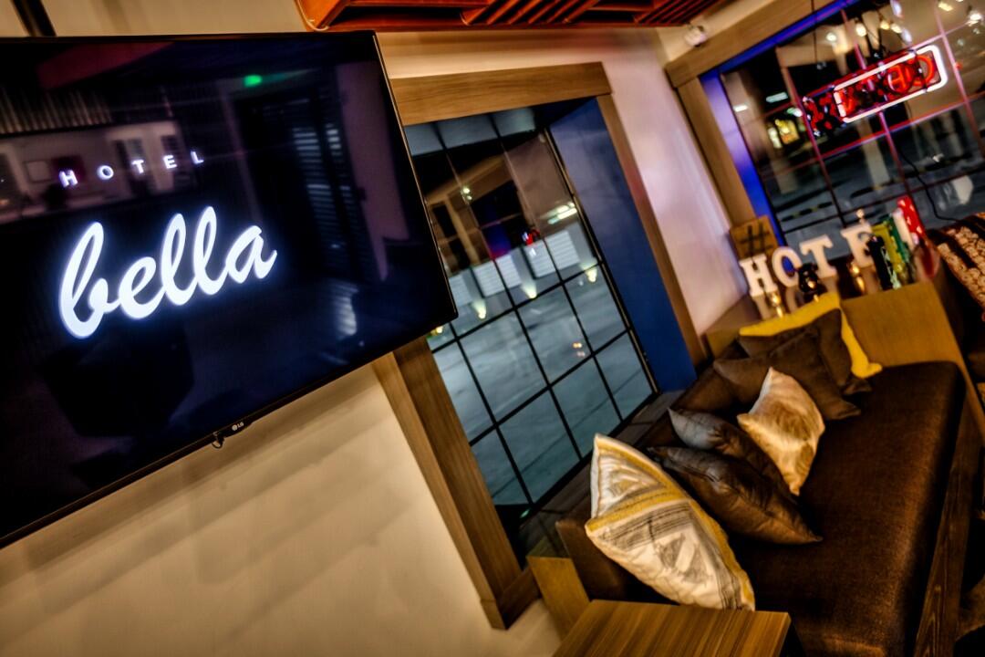 A lobby with a TV, couch, and neon signs