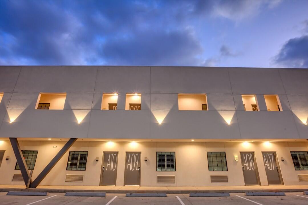 A two-story building with a parking lot in front of it