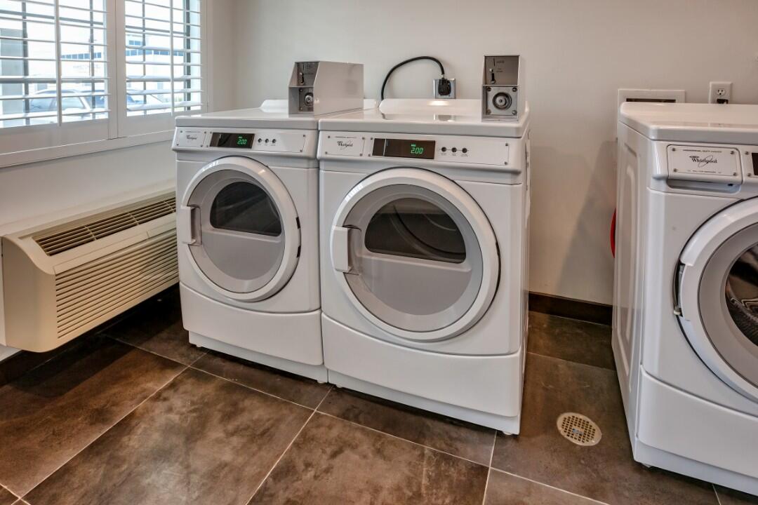 A laundry room with two washing machines and a sink